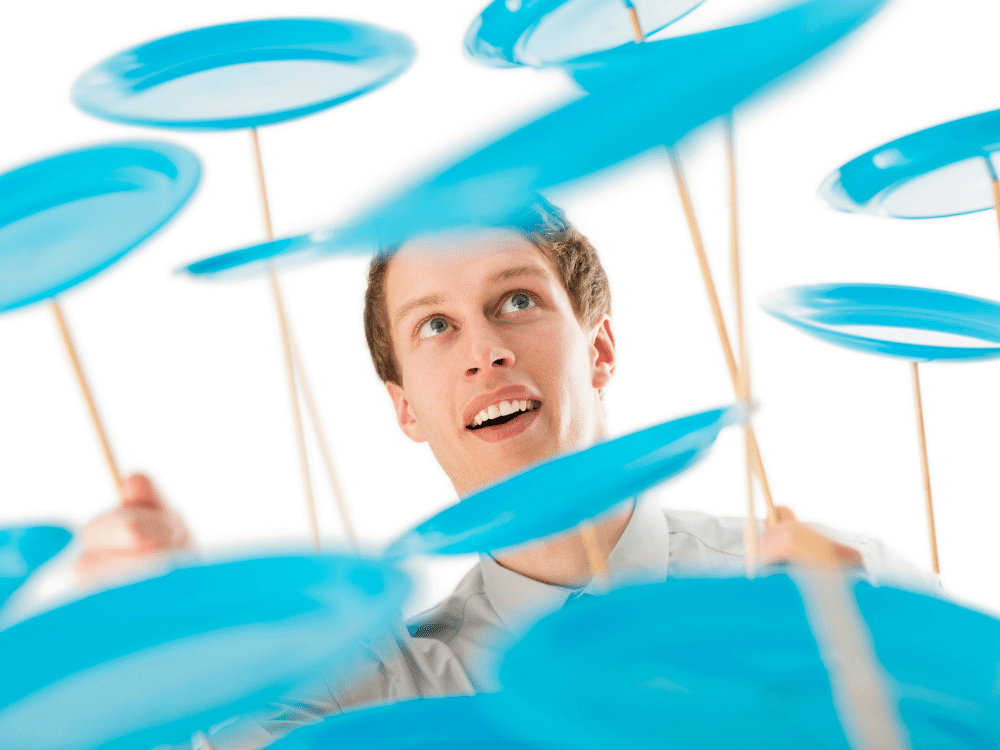 Man spinning dozens of blue plates on sticks.