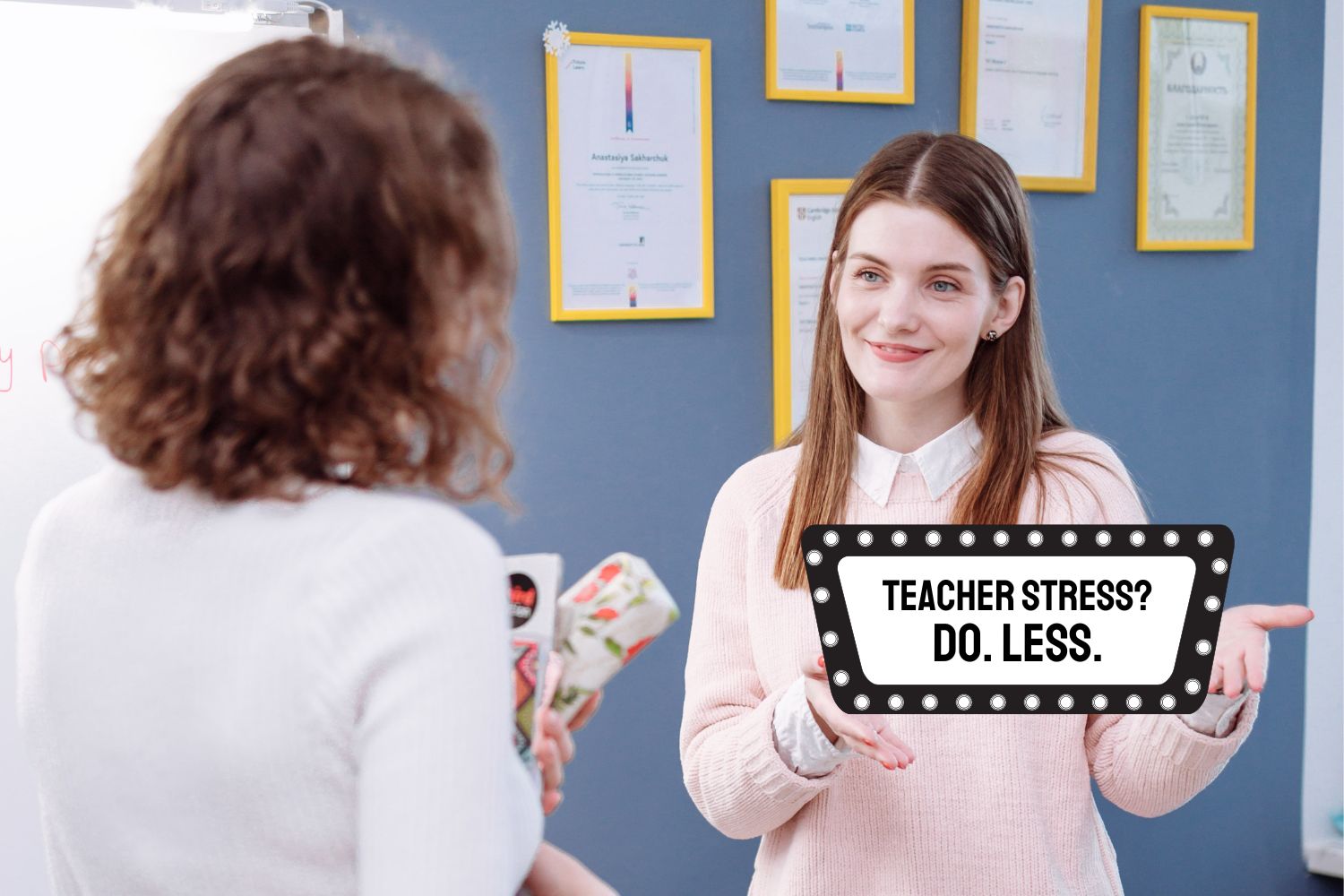 A woman in class who is quiet quitting teaching holds up a sign sign that says, "Teacher stress? Do less."