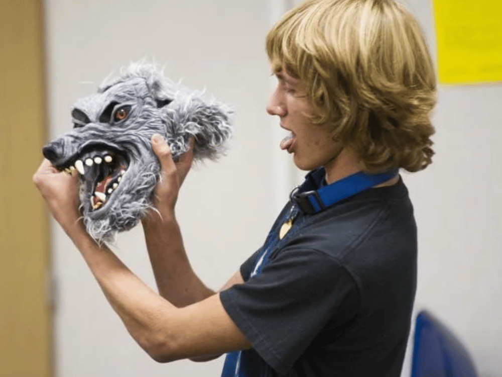 Boy holding a wolf mask.