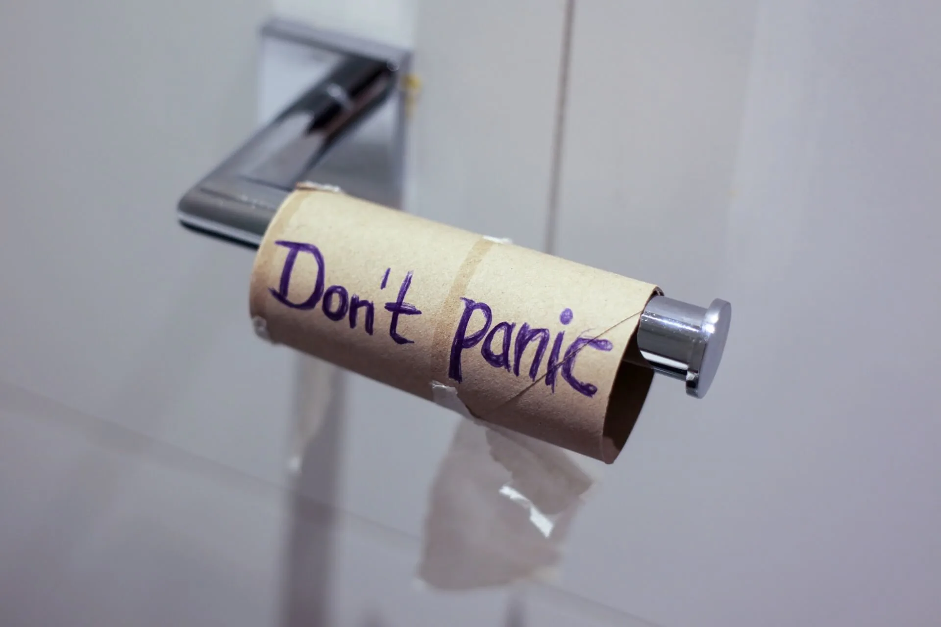An empty toilet roll in the school bathroom with the words "Don't Panic" written on it.