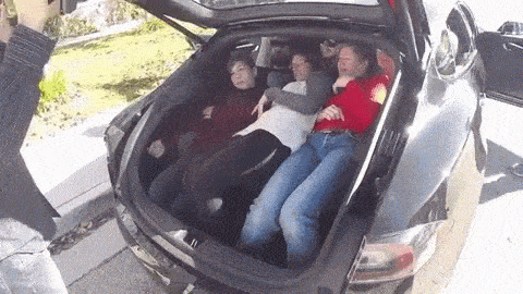 A GIF of a car trunk being closed a student on several other students lying in the back.