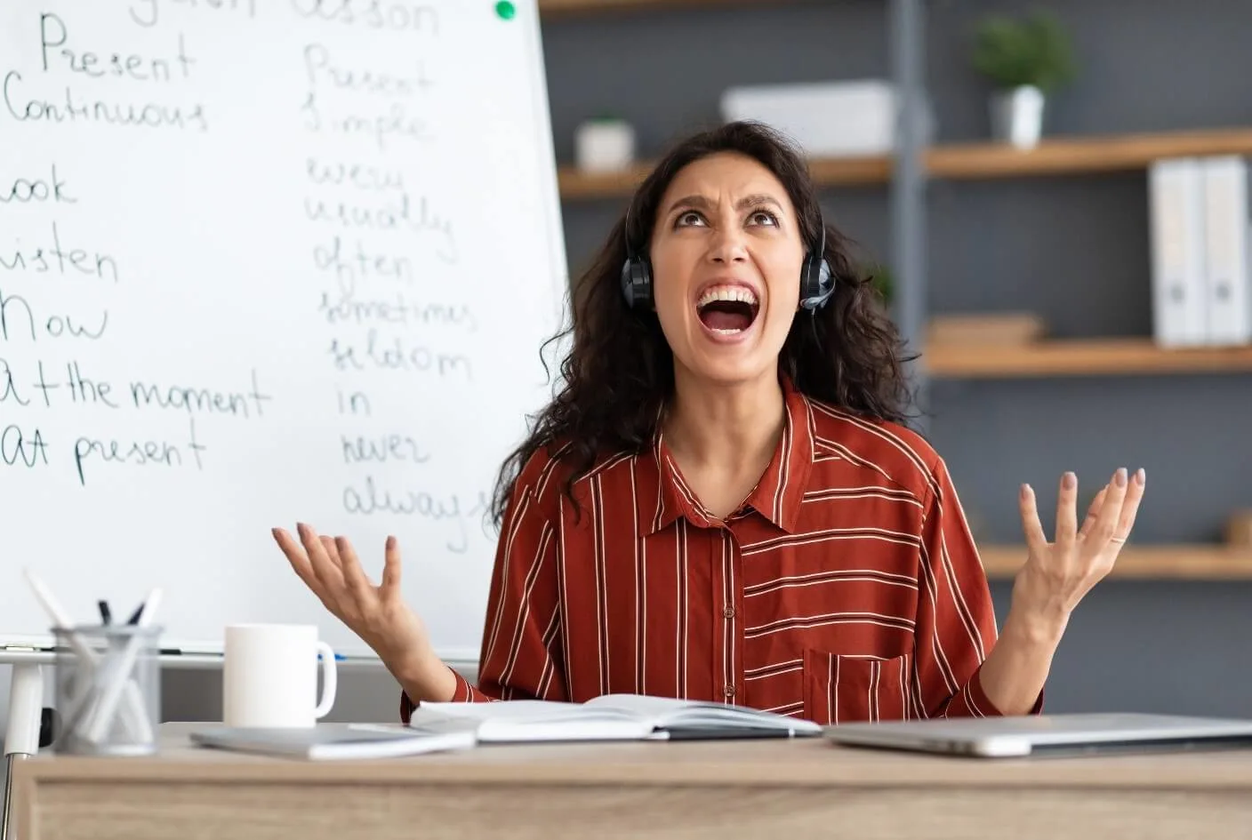 A teacher with headphones on screaming from all the overwhelming stress of her job.