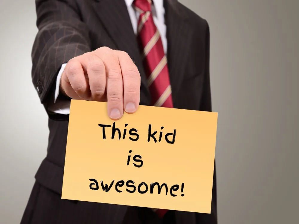 A teacher holding out is recommendation letter for a student reading "This kid is awesome!"
