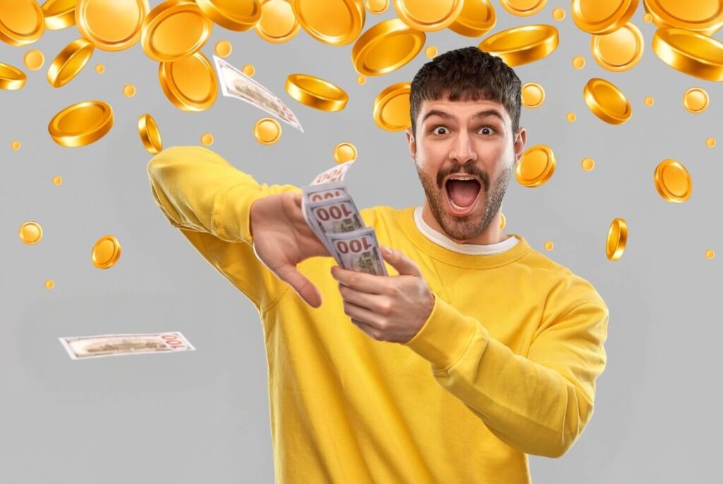 An excited teacher in a yellow sweater making it rain cash he earned at a successful school fundraiser.