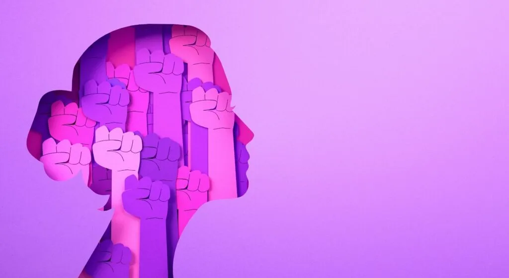 A cutout of a woman's head on a purple background with many fists of solidarity inside.